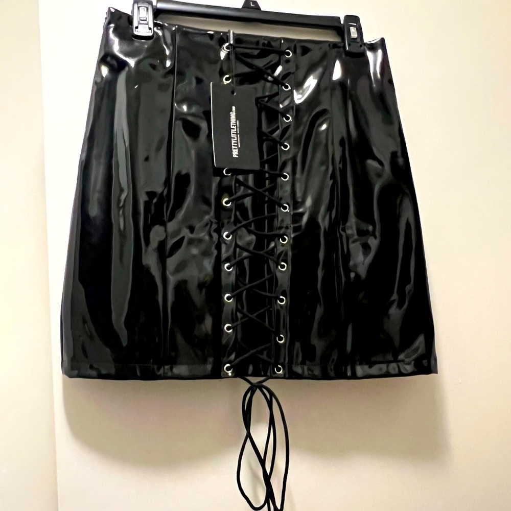 Black lace up patent leather skirt. Never worn. Size 8 fits like a medium
